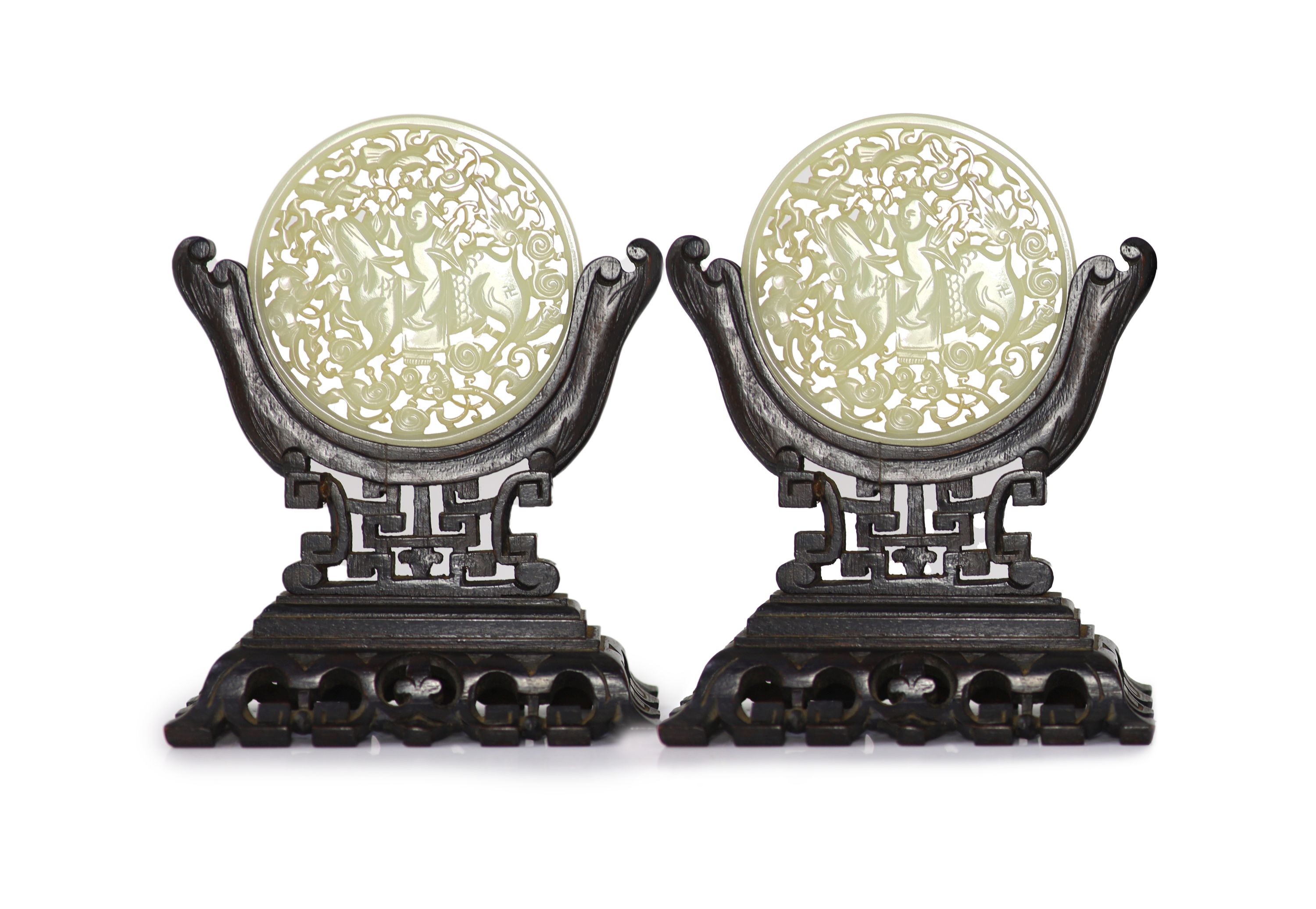 A pair of Chinese pale celadon jade circular plaques, late 19th century, 8.5cm, wood stands